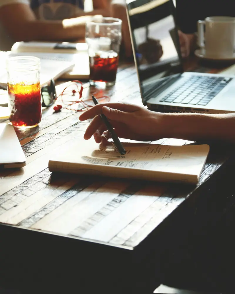 Une équipe en train d'écouter et de prendre des notes autour d'une table