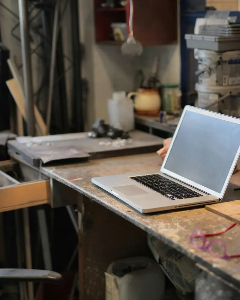 Atelier d'artisan avec un ordinateur portable au milieu des outils